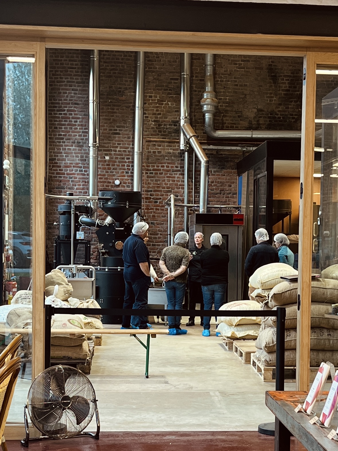 Visiteurs en visite guidée dans l’atelier de la Manufacture Encuentro, derrière la verrière.
